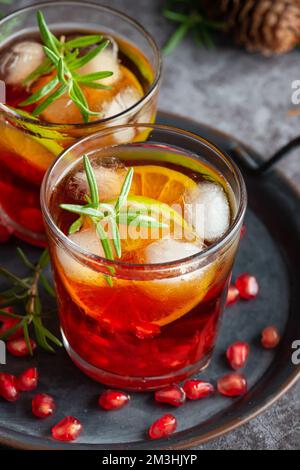 Cocktail di melograno decorato con lime, rosmarino e ghiaccio, bevanda fredda Foto Stock