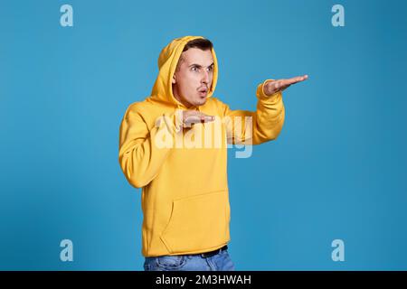 uomo divertente positivo in felpa gialla danzante Foto Stock