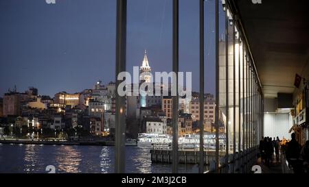 Guarda attraverso la finestra sulle luci di una città costiera e sull'acqua increspata. Azione. Città meridionale in tarda serata Foto Stock