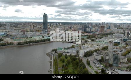 Serbia, Belgrado - 16 giugno 2022: Vista aerea di una città estiva su uno sfondo cielo nuvoloso blu. Riprese in stock. Volando sopra le strade verdi e l'edificio Foto Stock