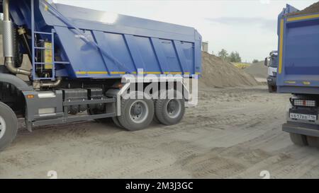 Serbia, Belgrado - 30 luglio 2021: Autocarri che si sostituiscono l'uno con l'altro. Scenografia. I dumper sono in fase di guida in cantiere. Sostituzione dei dumper in loco Foto Stock