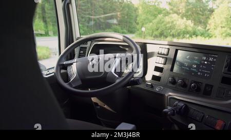 Vista all'interno della vettura. Scene.A grande volante nero all'interno di un camion che è in piedi e una foresta verde può essere visto nella finestra. Alta qualità 4K fo Foto Stock