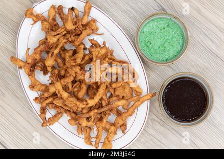 Vista dall'alto di un antipasto croccante di cipolle bhaji fritto servito con humus e salsa da immersione. Foto Stock