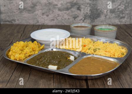 Tradizionale pasto indiano in un vassoio diviso con tutti i piatti vegetariani favoriti insieme con salsa humus dipping. Foto Stock