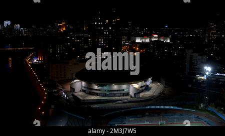 Paesaggio notturno , vista dall'alto . Stock footage . Una vista della città al buio, dove si può vedere un campo di calcio, una strada, edifici alti e y Foto Stock