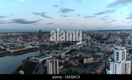 Vista aerea di un moderno grattacielo di uffici in vetro con riflessi della città nelle finestre. Riprese in stock. Volare sopra la città moderna su un Foto Stock