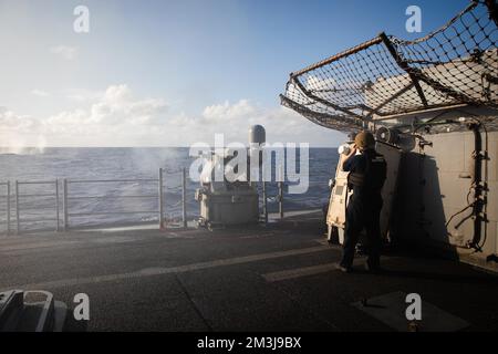 221213-N-YV347-1119 OCEANO PACIFICO (13 dicembre 2022) l'incrociatore missilistico guidato di classe Ticonderoga USS Bunker Hill (CG 52) attiva la mitragliatrice MK da 38 25 mm durante un esercizio di fuoco vivo. Bunker Hill, parte del Nimitz Carrier Strike Group, è attualmente in corso di svolgimento di operazioni di routine. (STATI UNITI Foto Navy di Mass Communication Specialist 3rd Class Jordan Jennings) Foto Stock