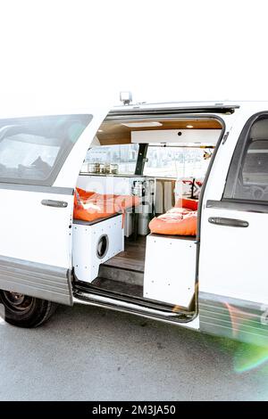 Bella luce naturale brillante che entra e illumina un vecchio campervan auto convertito per la vita del furgone. Il veicolo da diporto Vanlife è dotato di o. Foto Stock