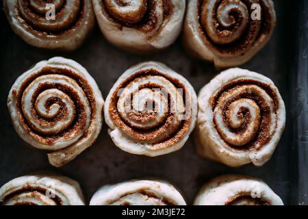 Primo piano di tre dolci alla cannella non cotti Foto Stock