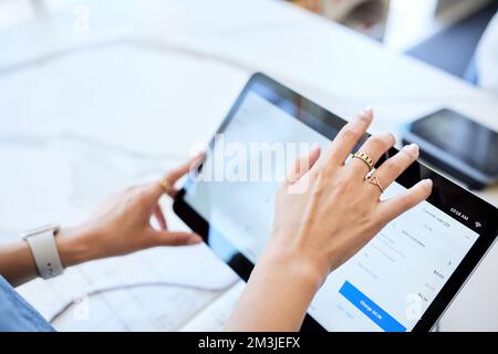 Mani di donna tagliate utilizzando il tablet digitale al banco cassa Foto Stock