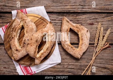 I tradizionali panini cotti in casa serbi (lepinja) e le spighe di grano maturo su tavola di legno. Foto Stock