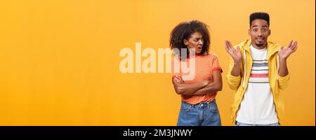 Jeez uomo che il vostro problema. Offeso dispiaciuto afroamericano elegante e attraente ragazza che guarda il ragazzo comportandosi cool fingendo lui Foto Stock