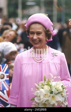La regina Elisabetta II, una visione in rosa, che porta un bouquet, sorride ampiamente mentre viene accolta dalla folla durante una passeggiata a Londra durante le celebrazioni del Giubileo d'Argento del 1977. Data: 1977 Foto Stock