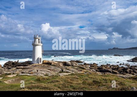 Faro a Muxia sulla Costa da morte in Galizia, Spagna con mare e cielo blu. Capo Vilan sullo sfondo Foto Stock