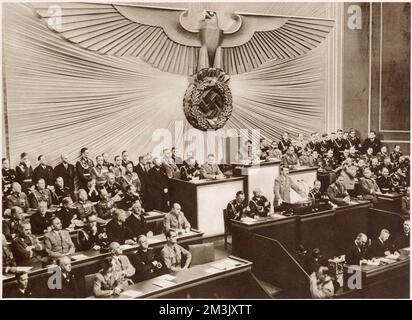 Adolf Hitler si è rivolto alla prima riunione del Grande Reichstag tedesco al Teatro dell'Opera di Kroll, Berlino, 30th gennaio 1939. L'aquila gigante sullo sfondo è rappresentativa del controllo nazista del Reichstag e del potere del 'Fuhrer', Adolf Hitler. Foto Stock