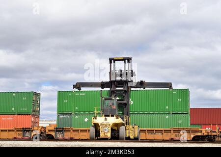 Franklin Park, Illinois, Stati Uniti. Un dispositivo di sollevamento a forche che accede alle unità container a bordo di un treno merci in una struttura intermodale in un cantiere ferroviario. Foto Stock