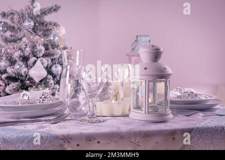 Festa tavolo di Natale impostazione con argenteria, candele e decorato albero di Natale Foto Stock