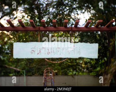 Il segno di legno scritto su di esso e detto 'สนามเด็กเล่น' significa parco giochi. Foto Stock