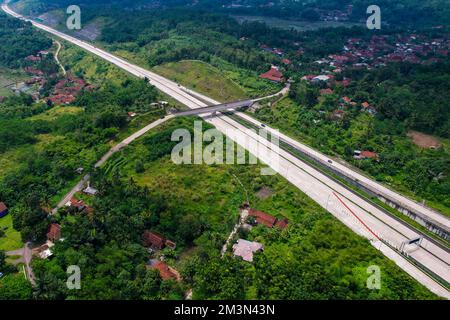 Sumedang, Giava Occidentale, Indonesia. 16th Dec, 2022. I veicoli con vista aerea sono visti attraverso la strada a pedaggio di Cileunyi-Sumedang-Dawuan (Cisumdawu) a Sumedang. Due sezioni della strada a pedaggio di Cisumdawu dalla porta a pedaggio di Pamulihan alla porta a pedaggio di Sumedang Cimalaka sono state testate per il pubblico per supportare le stagioni natalizie 2022 e Capodanno 2023. (Credit Image: © Algi Libri Sugita/ZUMA Press Wire) Credit: ZUMA Press, Inc./Alamy Live News Foto Stock