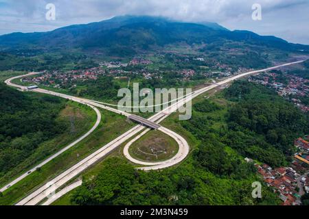 Sumedang, Giava Occidentale, Indonesia. 16th Dec, 2022. I veicoli con vista aerea sono visti attraverso la strada a pedaggio di Cileunyi-Sumedang-Dawuan (Cisumdawu) a Sumedang. Due sezioni della strada a pedaggio di Cisumdawu dalla porta a pedaggio di Pamulihan alla porta a pedaggio di Sumedang Cimalaka sono state testate per il pubblico per supportare le stagioni natalizie 2022 e Capodanno 2023. (Credit Image: © Algi Libri Sugita/ZUMA Press Wire) Credit: ZUMA Press, Inc./Alamy Live News Foto Stock