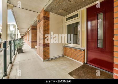 Corridoio con porta situato nella sala illuminata di un edificio contemporaneo di appartamenti Foto Stock