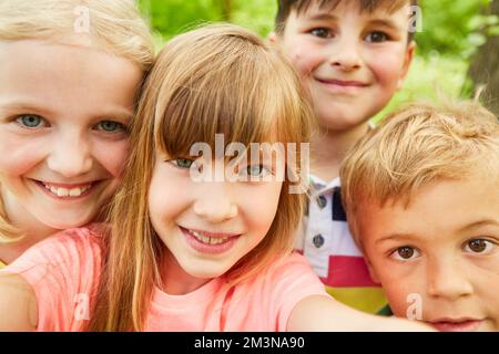 Felice multirazziale ragazze e ragazzi che prendono selfie nel parco durante le vacanze estive Foto Stock
