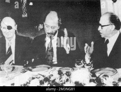 Anwar Sadat d'Egitto (1918-1981) in una cena di Stato in suo onore, seduto tra Moshe Dayan (1915-1981) e il primo ministro israeliano Menachem Begin (1913-1992). Sadat divenne il primo leader arabo a mettere piede in Israele nei suoi 29 anni di esistenza quando arrivò a Tel Aviv all'inizio della sua visita di due giorni. Data: Novembre 1977 Foto Stock