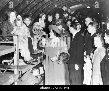 Re e regina in visita ai bambini nei rifugi sotterranei Foto Stock