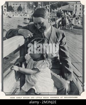 Herr Adolf Hitler e Little Helga Goebbels a Heiligendamm. Hitler sedette su una panchina accanto a Helga, la figlia maggiore di Joseph Goebbels, (3 anni in questa foto) nella località balneare di Heiligendamm sul Baltico. Data: 1935 Foto Stock