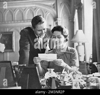 Principessa Margaret (1930 - 2002) e la sua fidanzata, Antony Armstrong-Jones (Lord Snowdon) che legge telegrammi di auguri inviati in seguito all'annuncio del loro impegno. Data: 1960 Foto Stock