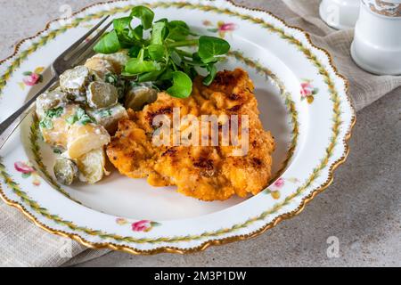 Schnitzel di maiale al limone e timo con insalata di patate Foto Stock