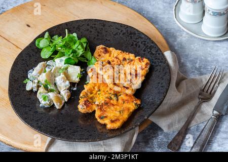 Schnitzel di maiale al limone e timo con insalata di patate Foto Stock