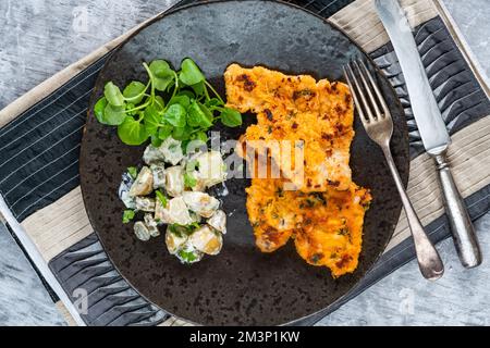 Schnitzel di maiale al limone e timo con insalata di patate Foto Stock