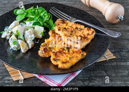 Schnitzel di maiale al limone e timo con insalata di patate Foto Stock