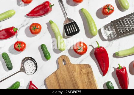 Sfondo con verdure e utensili da cucina su un tavolo bianco. Ingredienti. Preparazione del cibo. Foto Stock