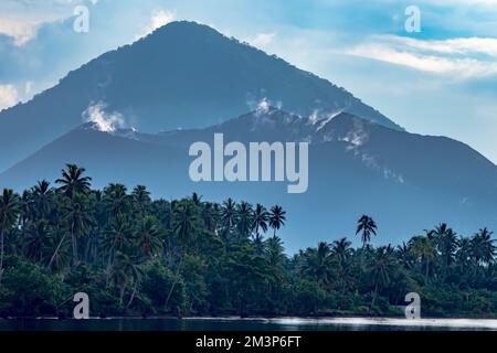 Nuvole che si formano sopra il vulcano nell'Oceano Pacifico meridionale - anello di fuoco Vulcano in Papua Foto Stock