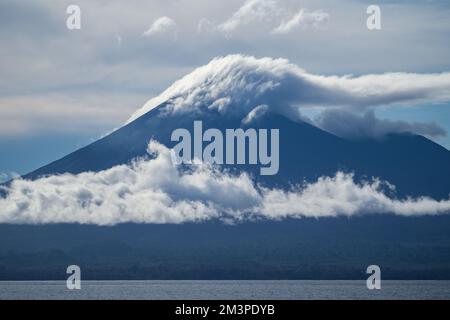 Nuvole che si formano sopra il vulcano nell'Oceano Pacifico meridionale - anello di fuoco Vulcano in Papua Foto Stock