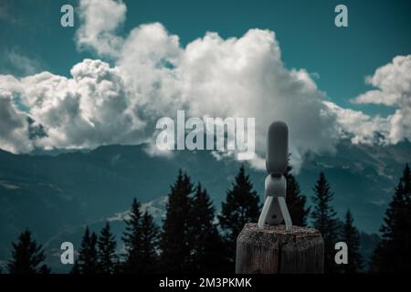La minuscola e potente Action camera posta su un legno di legno prima della vista panoramica della natura Foto Stock