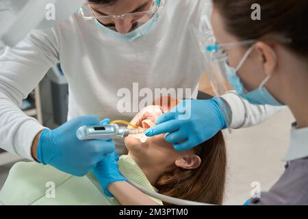 Stomatologo esperto che dà anestesia al cliente prima del trattamento dei denti Foto Stock