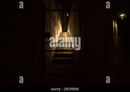 Scala bloccata da un cancello metallico di notte Foto Stock