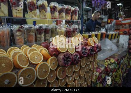 Tel Aviv, Israele. 16th dicembre 2022. Un negoziante prepara bevande di frutta al mercato Shuk Hacarmel, un mercato all'aperto fondato negli anni '1920s Foto Stock