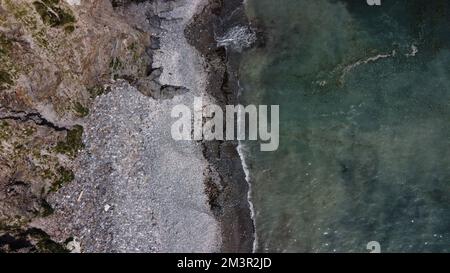 Bellissima spiaggia rocciosa sulla costa meridionale dell'Irlanda vicino a Clonakilty. La pittoresca costa del Mar Celtico. Surf in mare. Acque turchesi dell'Atlante Foto Stock