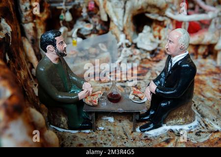 Napoli, Italia. 16th Dec, 2022. Figurine del presidente ucraino Volodymyr Zelensky e del presidente russo Vladimir Putin siedono uno di fronte all'altro a un tavolo da pizzeria, condividendo una pizza ''Margherita'' e bevendo vino: La scena fa parte di una scena natività fatta interamente di pasta per pizza dal ristoratore Mauro Espedito . Credit: Independent Photo Agency/Alamy Live News Foto Stock