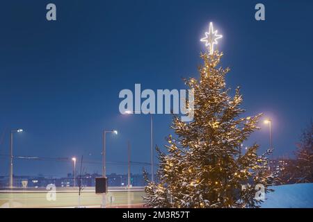 Albero di Natale illuminato in quartiere residenziale. Decorazione di Natale in città durante l'avvento. Praga, Repubblica Ceca Foto Stock