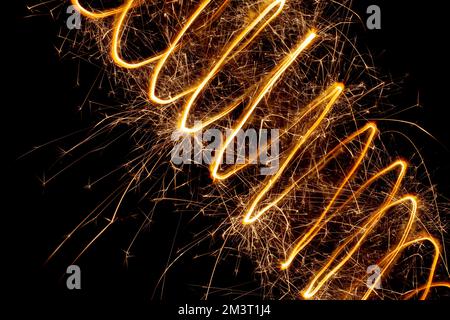 Una spirale di luce con scintille su sfondo nero. Scintille astratte di fuochi d'artificio Foto Stock