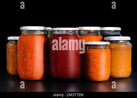 Verdure sottaceto su fondo nero. Conservazione in vasetti di vetro. Ingredienti per inscatolare le verdure Foto Stock