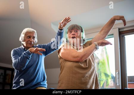 Coppia anziana che si diverte a casa, coppia anziana che balla e sorridente indoor, stile di vita anziano Foto Stock