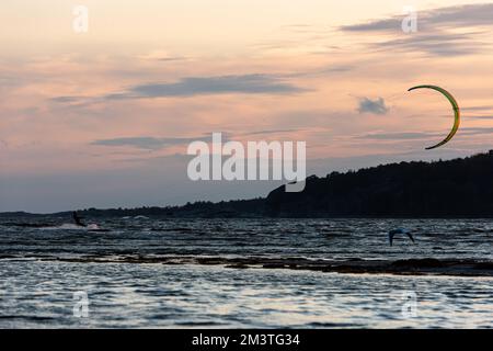 Gothenburg, Svezia - 10 2021 ottobre: Kitesurf kitesurf kitesurf al tramonto su una spiaggia Foto Stock