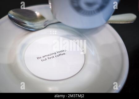 Piccola carta rotonda per messaggi personali sotto una tazza di caffè. Foto Stock