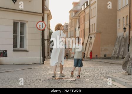 Una famiglia sta passeggiando sulle pietre di pavimentazione in una vecchia città europea. Foto Stock